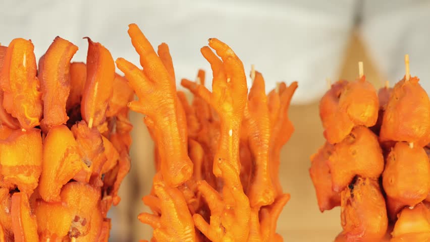 Brightly seasoned chicken feet and heads displayed as authentic Asian delicacy