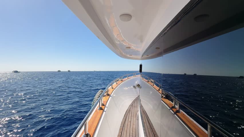 Close up view of yacht deck side with tinted window floating in the blue sea water