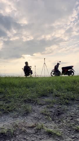 Man Taking Photo With Motorcycle At Sunset
