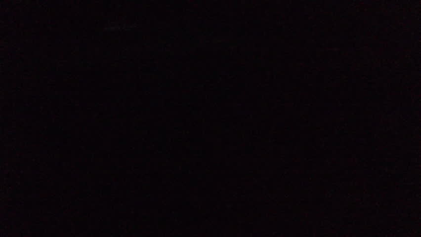Bioluminescence from drone. Aerial night view of the sea surface with breaking wave shining blue light caused by bioluminescence. High level of noise