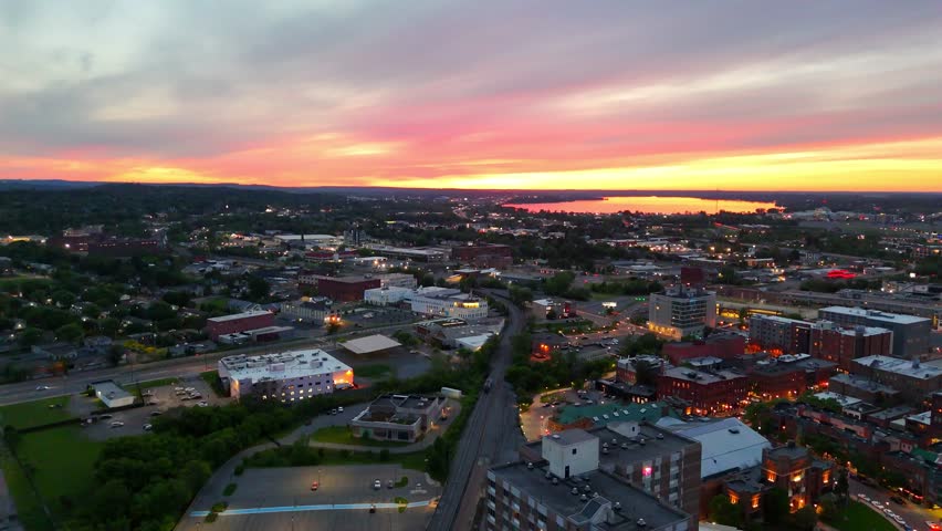 The sun sheds its last bit of light over the urban landscape as it dives beneath the horizon, leaving all of the buildings within the city to begin operating on artificial light.
