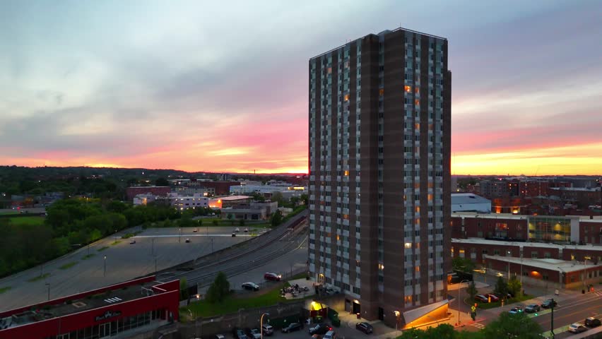 The sun sheds its last bit of light over the urban landscape as it dives beneath the horizon, leaving all of the buildings within the city to begin operating on artificial light.