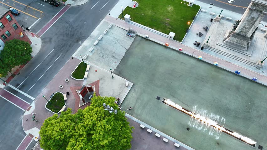 Families, kids, teenagers, and couples, congregate around this public space featuring a fountain and a landmark located in the center of the city.