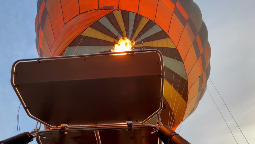 A hot air balloon is being inflated at dawn. Ideal for travel and adventure content.