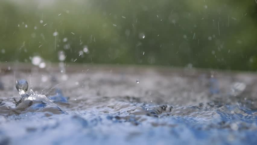 Drops fall on a water surface and splash with water. Raindrops.