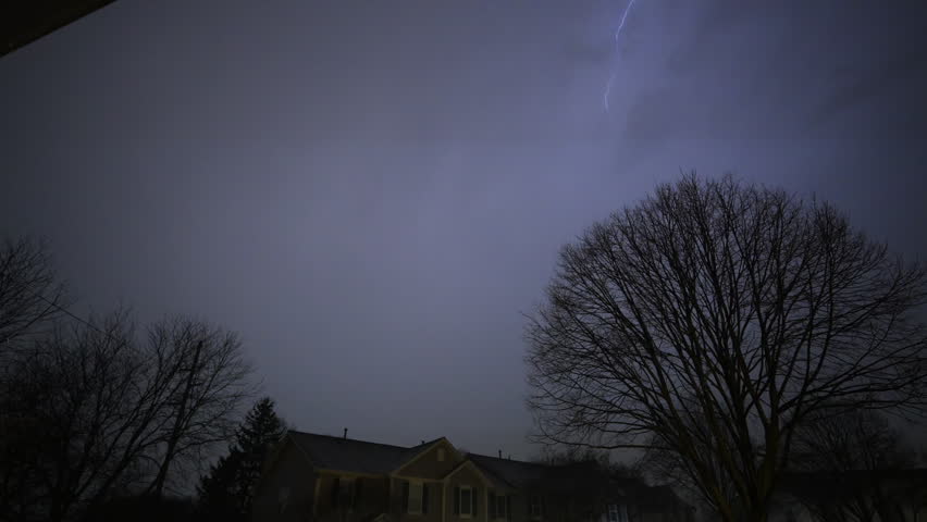 Stormy sky. A lot of Flashing lightening of thunderstorm strike the sky above trees and house