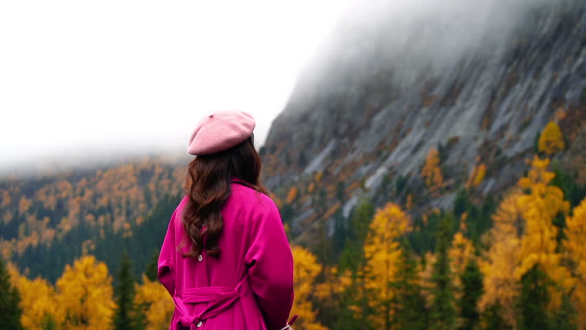 Tourists are taking photos at Siguniangshan in autumn, Sichuan in China.