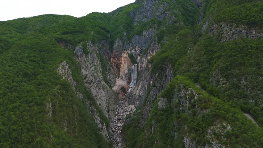 Scenic Boka waterfall cascade from karst spring over cliff in Bovec. Aerial