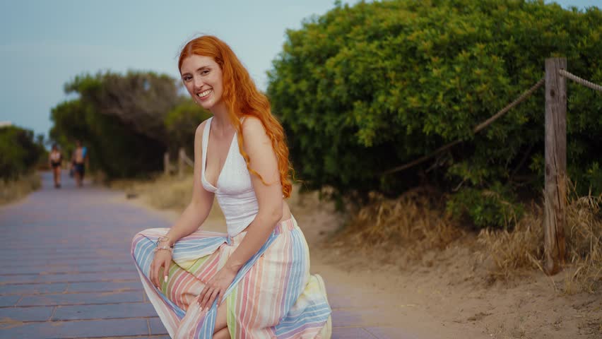 Red haired woman going out with doodle dog on boardwalk