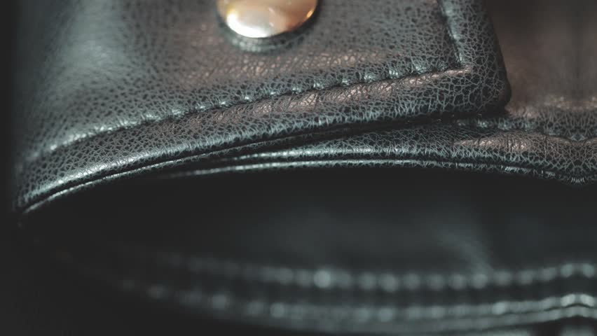 Close-up shot of a leather wallet with a button, perfect for travel or daily use.
