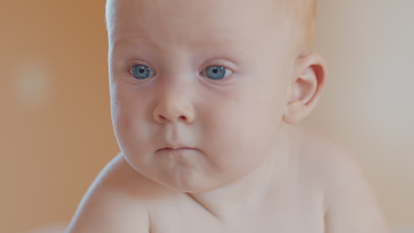 Infant baby with blue eyes looks into the camera