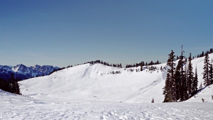 Footage of a stunning, snow-covered mountain landscape in the Paradise area of Mount Rainier National Park, Washington. The view is from the popular Skyline Trail heading towards Panorama Point, a fre