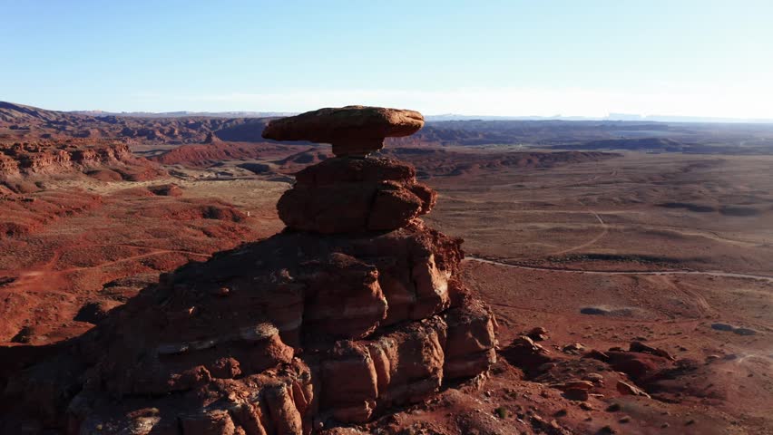 Pull back close to wide shot of Mexican Hat Rock in Utah near sunset.
