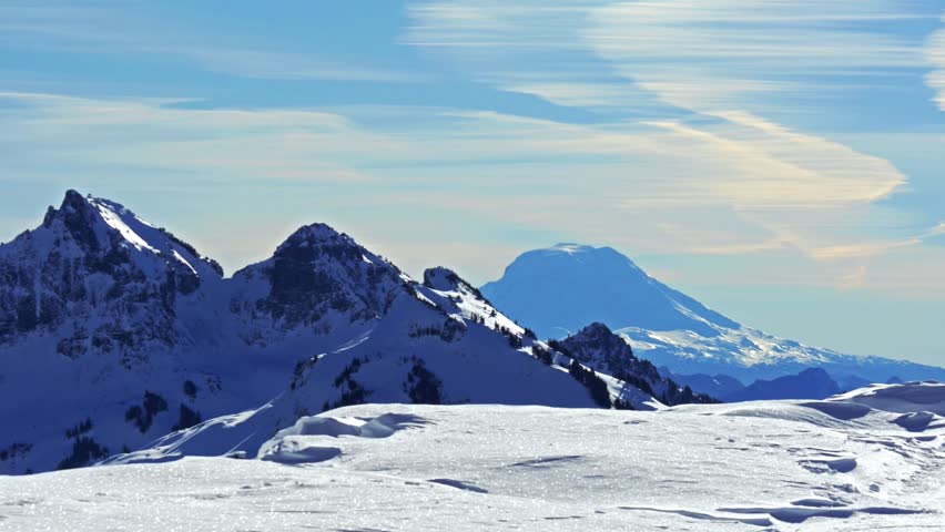 panoramic view of the snow-covered landscape and distant Mount Adams, as seen from the high-elevation Skyline Trail near Panorama Point in Mount Rainier National Park, Washington, USA.