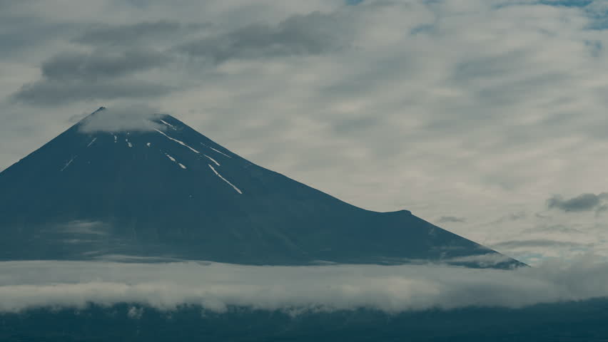 Timelapse of Fuji Mountain in Japan Mountain peak above cloud layer in cloudy sky, calm scenic landscape with snow and mist, volcanic mountain snow cap ridge horizon nature