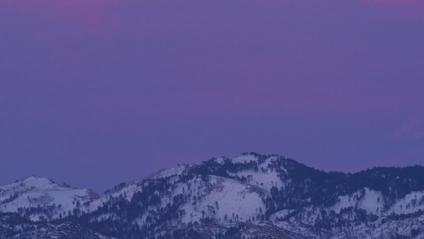 Time lapse of the full moon rising over snowy mountain peaks, San Bernardino National Forest, California, filmed from Lake Arrowhead, California.