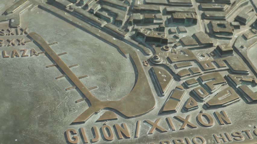 Close up shot of a detailed bronze three dimensional relief city map with text inscription of Gijon Xixon in Asturias, Spain.