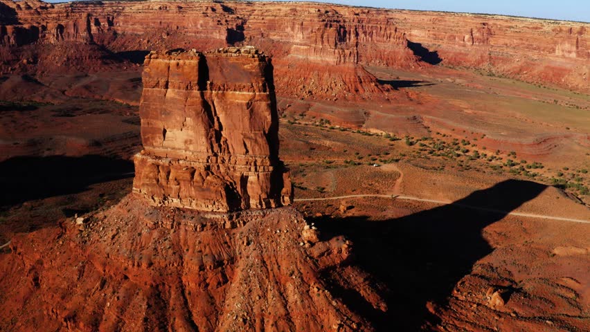 Drone aerial circling shot of rock butte in Valley of the Gods, Utah near sunset.