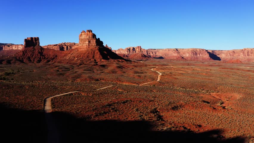 Wide aerial shot of dirt road approaching Valley of the Gods, Utah.