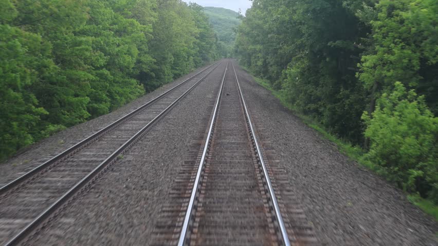 view of moving train tracks from the back of metro car window new york jersey transit north (riding subway travel transportation) gravel rail track bed