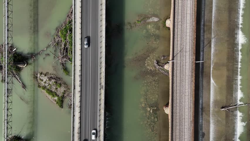 Road and railway bridges crossing the Trebbia River near Piacenza, Emilia-Romagna, Italy, showing river channels, hydraulic infrastructure and transport corridors within the Po Valley, top down reveal