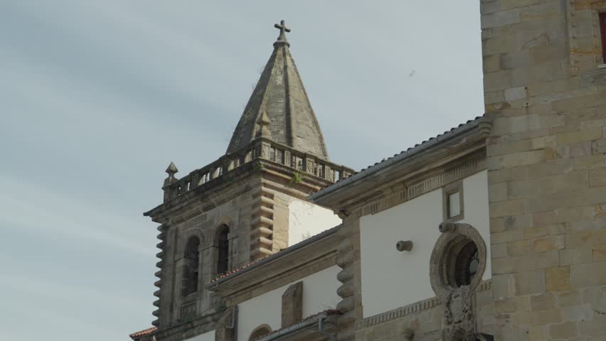 Low angle close up view of the historic stone tower and facade of the Revillagigedo Palace complex under a bright sky in Gijon, Asturias, Spain.