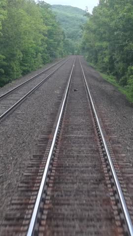 view of moving train tracks from the back of metro car window new york jersey transit north (riding subway travel transportation) gravel rail track bed