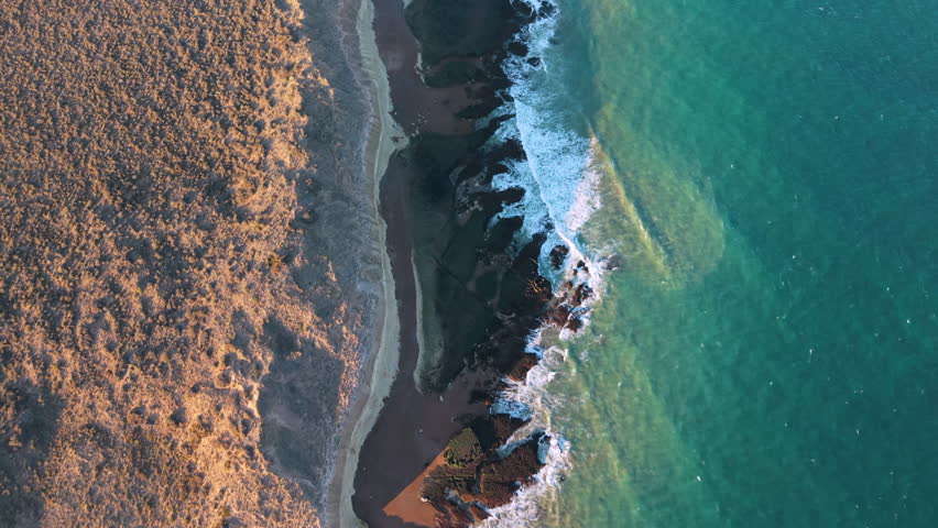 A stunning high-angle look at crashing waves along the rugged shoreline of Puerto Madryn.