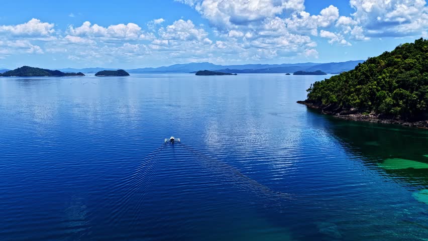 Motorboat sailing in the beautiful blue waters of El Nido, Palawan in the Philippines in aerial timelapse