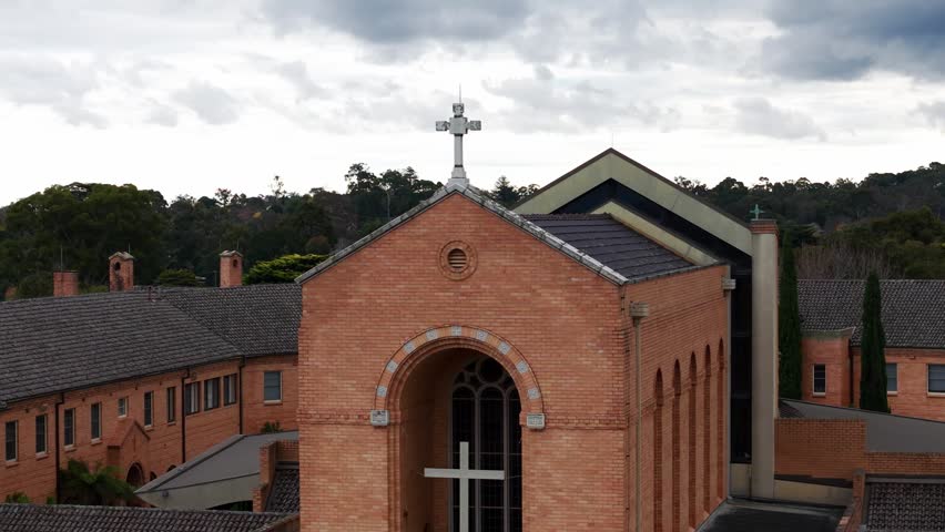 Christian church facade with a big cross on a cloudy day