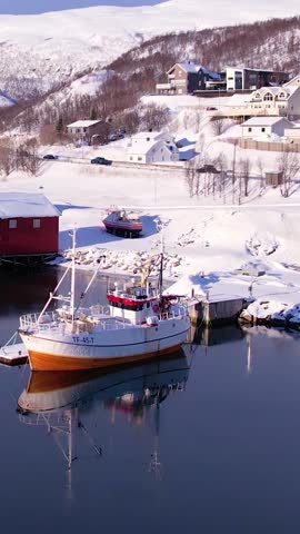 Aerial drone view of fishing boat in the port of northern Norway, Tromso. Sunny winter day