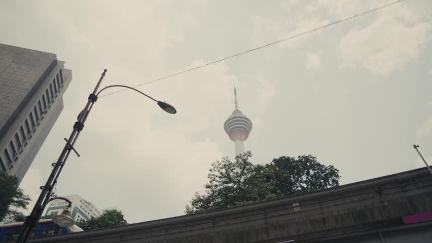 The Kuala Lumpur Tower in Malaysia, with a train passing in front.