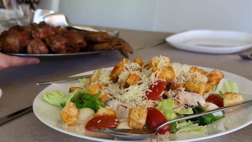 Fresh chicken Caesar salad featuring crisp romaine lettuce, juicy cherry tomatoes, seasoned croutons, and shredded Parmesan cheese.