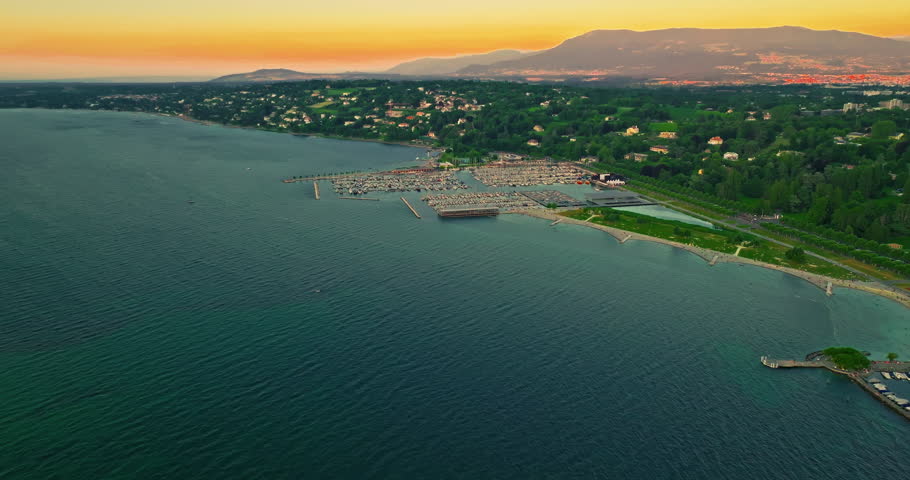 Establishing shot of Geneva city. Aerial view of the Swiss lake town. Rooftops of houses and the lake bay