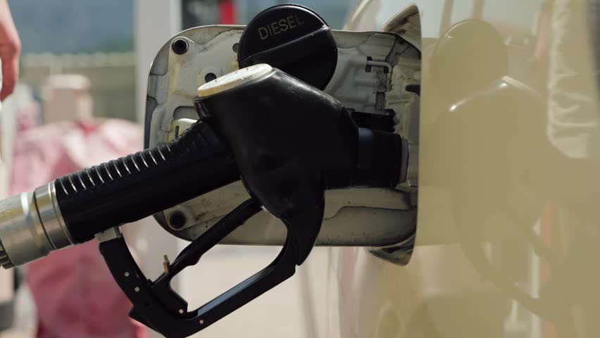 Close-up of a gasoline pump nozzle being removed from a vehicle fuel tank after refueling. Transportation and fuel station concept. High quality 4k footage