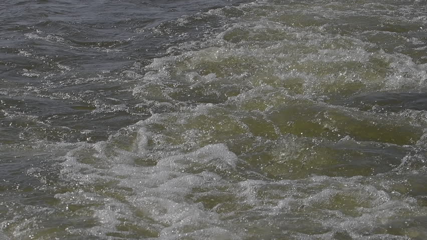 Water churns in the wake of a power boat on High Rock Lake, creating dynamic surface patterns on a summer day in North Carolina.