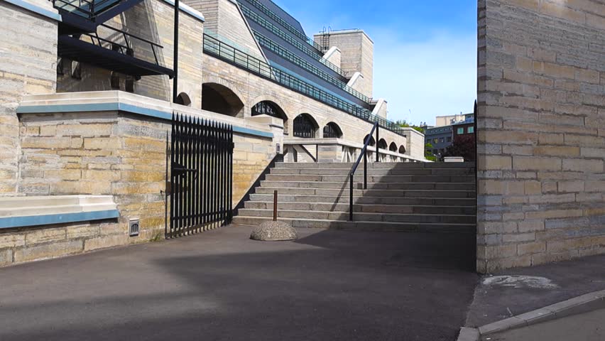 Stone building of the National Library of Estonia in Tallinn, a notable example of modernist architecture with its imposing staircase and unique design under a clear blue sky on a sunny day