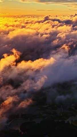 Bright orange sunset lighting dramatic cloud formations above the sky.