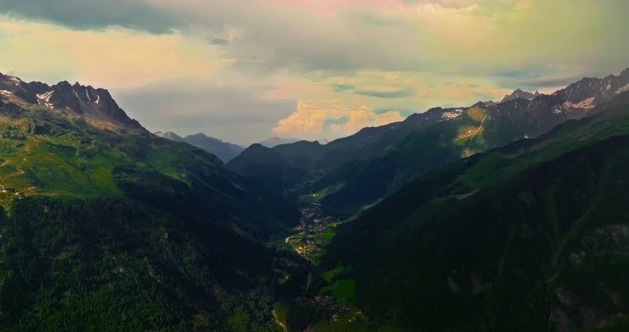 Establishing shot of French mountains in summer. Drone view of green meadows. Establishing shot of mountain range. Aerial slider shot of Chamonix village under Mont Blanc