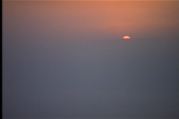 Sunrise over desert hills through morning mist in Israel.