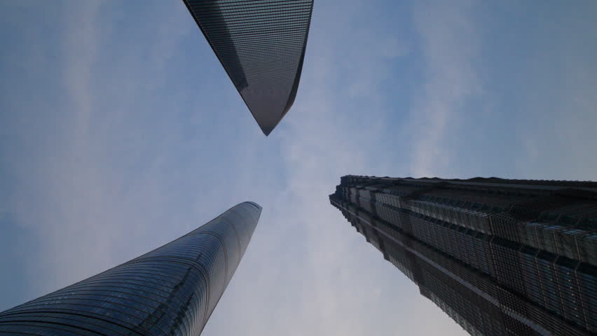 Looking up at modern skyscrapers against a cloudy sky in an urban city center