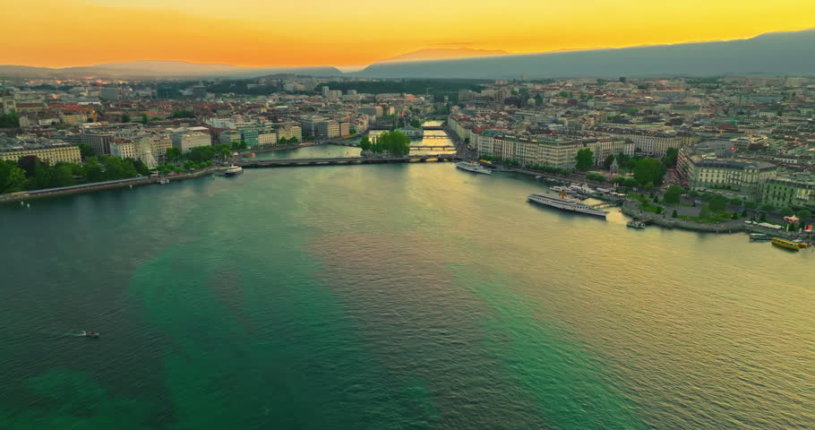 Establishing shot of Geneva city. Aerial view of the Swiss lake town. Rooftops of houses and the lake bay