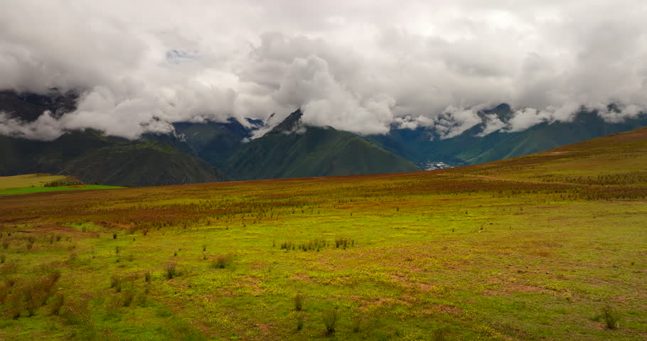 Aerial view of woman dancing and spinning expressing freedom in agricultural fields in Maras, Peru