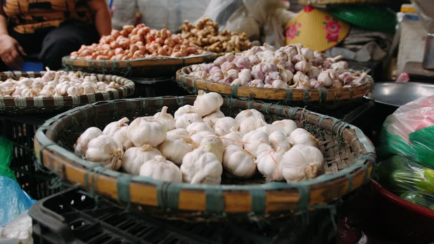 Garlic and onion for sale in baskets at a traditional vietnam street market in hanoi.
