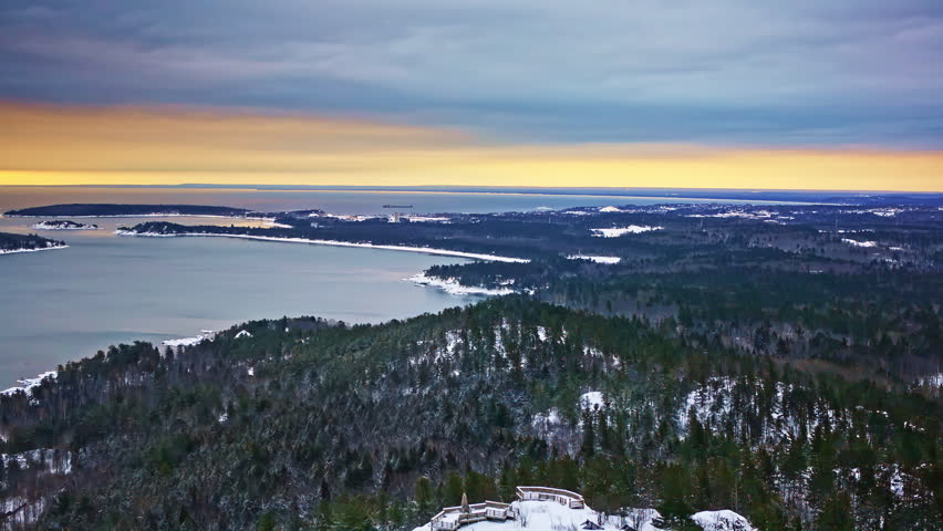 Sweeping aerial view of snowy forests and frozen terrain in northern Michigan.