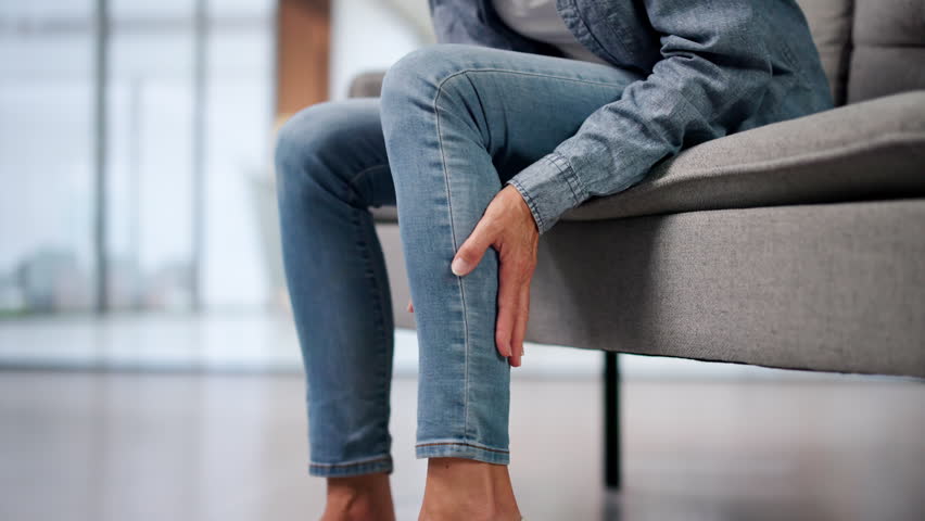 Mature Woman Gently Rubs Leg Easing Muscle Cramp And Swelling Discomfort.