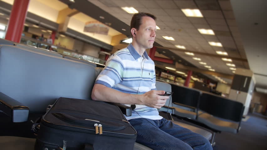 A man uses his smartphone in the airport.