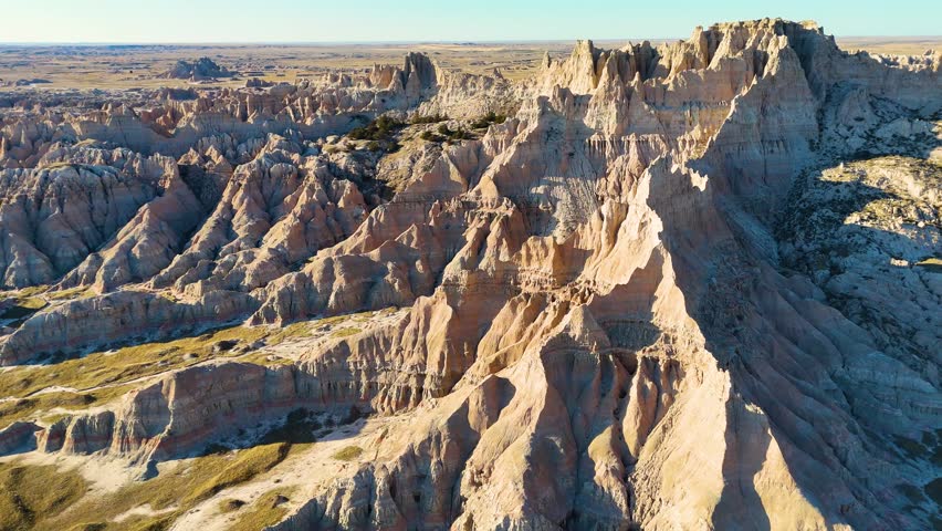 Cinematic Drone View of Dramatic Geological Landscapes, Deep Canyons, and Layered Cliffs in Badlands National Park, America. Car trip around USA