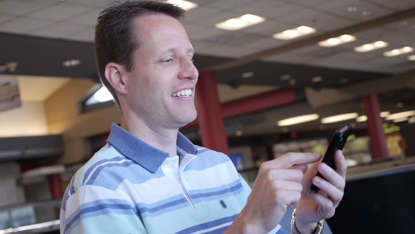 A man uses his smartphone in the airport.