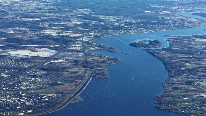 Daugava River and Riga Coastline with Islands and Surrounding Landscape in Latvia, Airplane Window Shot Dolly Left